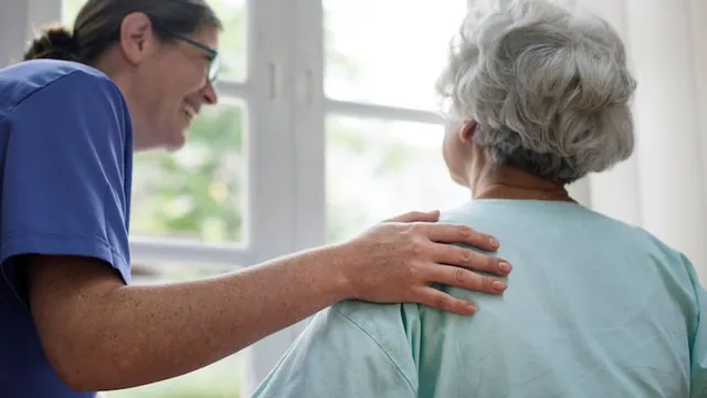 Nursing home staff helping patient