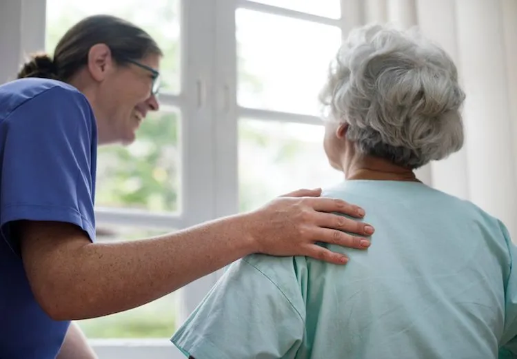 Nursing home staff helping patient